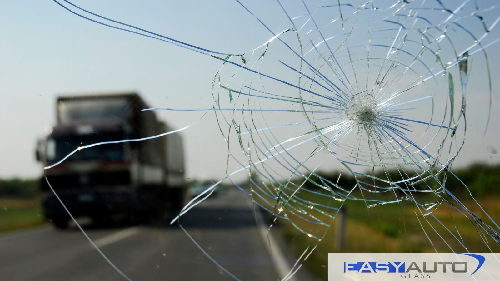 Looking through a cracked windshield while on a summer road trip