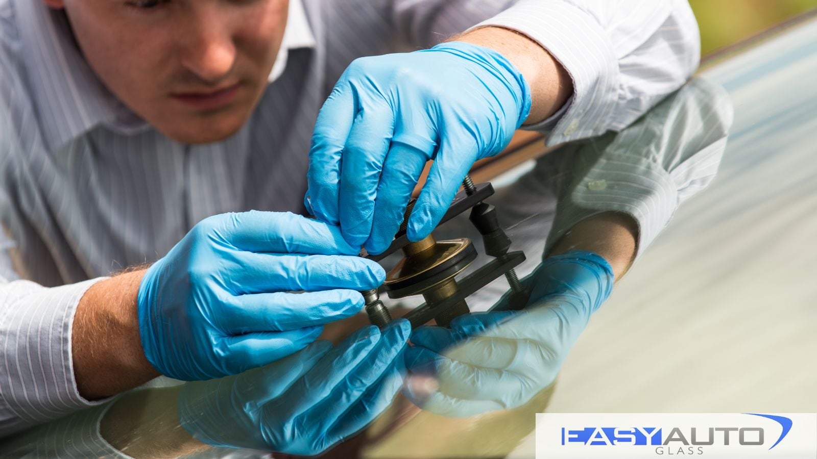 A man works on repairing a windshield.